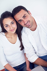 Image showing relaxed young couple working on laptop computer at home