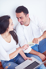 Image showing relaxed young couple working on laptop computer at home