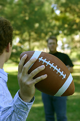 Image showing Two men throwing the football