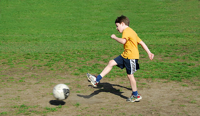 Image showing Boy kicking soccer ball