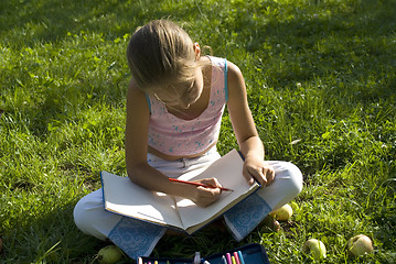 Image showing The girl draws on a meadow VI