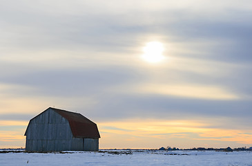 Image showing Old wooden barn in a snowy field