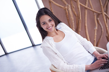 Image showing relaxed young woman at home working on laptop computer