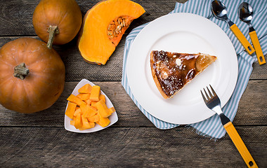 Image showing Piece of pie and Pumpkin slices on wooden table