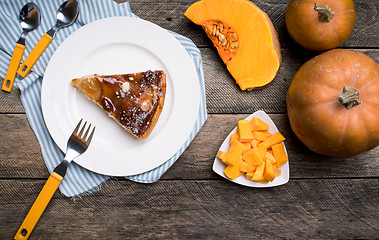 Image showing Piece of pie and Pumpkin slices on wood