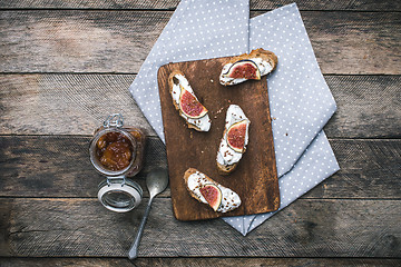 Image showing rustic style Bruschetta snack with jam and figs on napkin