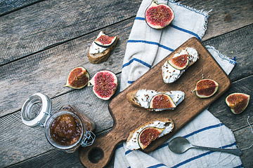 Image showing rustic style snacks with jam cheese and figs on wood board