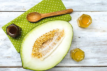 Image showing Cut melon with honey on napkin and rustic board