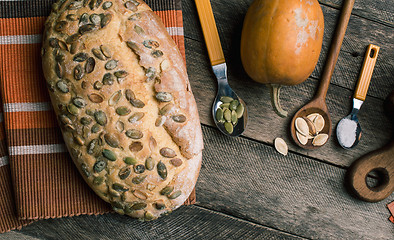 Image showing pumpkin with bread and seeds on Rustic wood