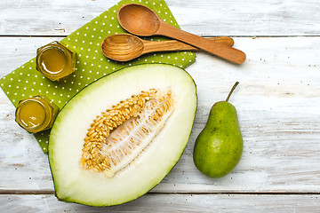 Image showing Healthy melon green pear and honey on rustic wood