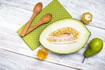 Image showing Healthy melon with pear and honey on rustic board