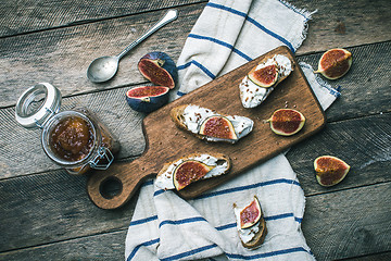 Image showing cut figs and Bruschetta snakcs with jam and on napkin