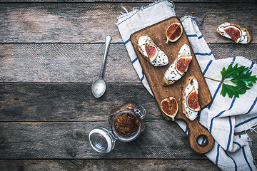 Image showing tasty Snacks with cheese jam and figs on wood