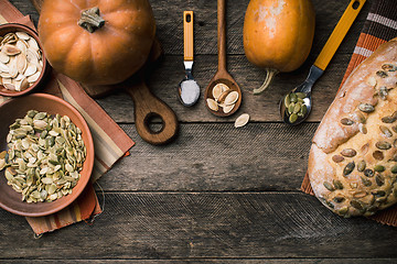 Image showing Rustic pumpkins with bread and seeds on wood