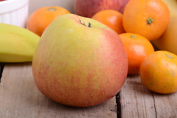 Image showing Bananas apple mandarin peach strawberry on wooden background as health food concept