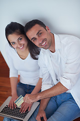 Image showing relaxed young couple working on laptop computer at home