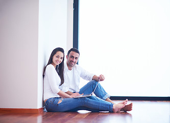 Image showing relaxed young couple working on laptop computer at home