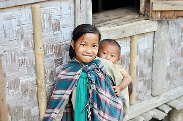 Image showing Smiling older sister carrying kids in Nagaland, India