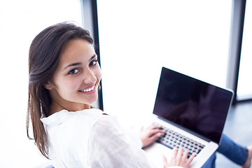 Image showing relaxed young woman at home working on laptop computer