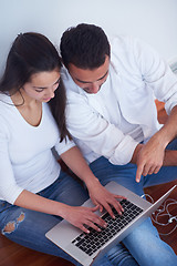 Image showing relaxed young couple working on laptop computer at home