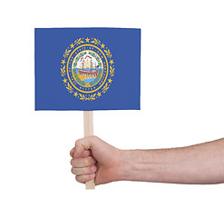 Image showing Hand holding small card - Flag of New Hampshire