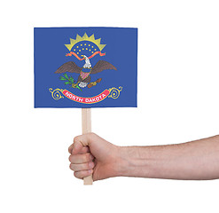 Image showing Hand holding small card - Flag of North Dakota