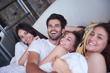 Image showing handsome man in bed with three beautiful woman