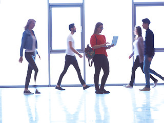 Image showing student girl standing with laptop, people group passing by