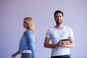 Image showing student working on tablet, people group passing by