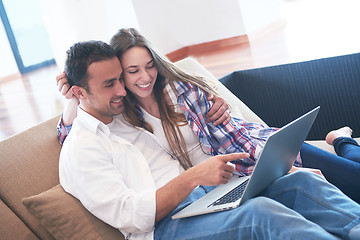 Image showing relaxed young couple working on laptop computer at home