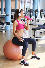 Image showing woman with headphones in fitness gym