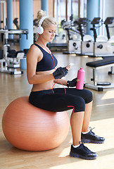 Image showing woman with headphones in fitness gym