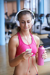 Image showing woman with headphones in fitness gym