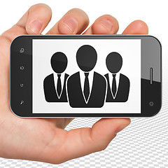 Image showing Business concept: Hand Holding Smartphone with Business People on display