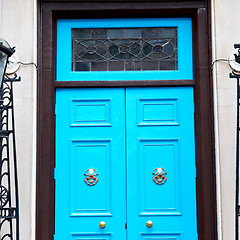 Image showing  blue handle in london antique brown door  rusty  brass nail and