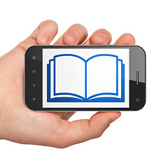 Image showing Science concept: Hand Holding Smartphone with Book on display