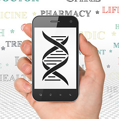 Image showing Healthcare concept: Hand Holding Smartphone with DNA on display