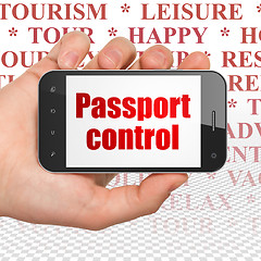 Image showing Vacation concept: Hand Holding Smartphone with Passport Control on display