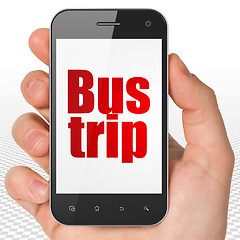 Image showing Travel concept: Hand Holding Smartphone with Bus Trip on display