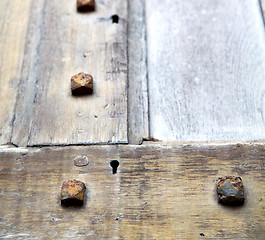 Image showing in london antique brown door  rusty  brass nail and light