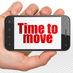 Image showing Time concept: Hand Holding Smartphone with Time to Move on display