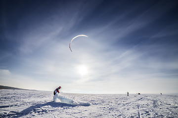 Image showing Kiteboarder with blue kite on the snow