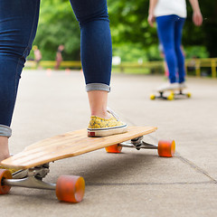 Image showing Teenage girl practicing riding long board.