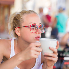 Image showing Woman drinking coffee outdoor on street.