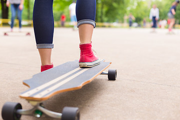 Image showing Teenage girl practicing riding long board.