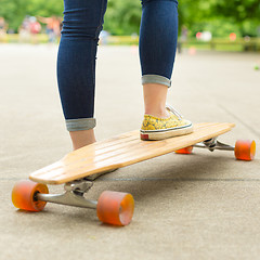 Image showing Teenage girl practicing riding long board.