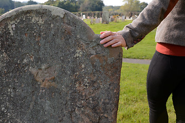 Image showing Woman\'s hand resting on a gravestone