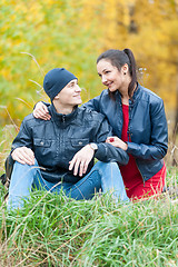 Image showing Young romantic couple sits on plaid. Autumn picnic