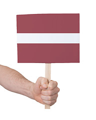 Image showing Hand holding small card - Flag of Latvia