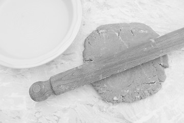 Image showing Rolling out homemade pastry with a rolling pin